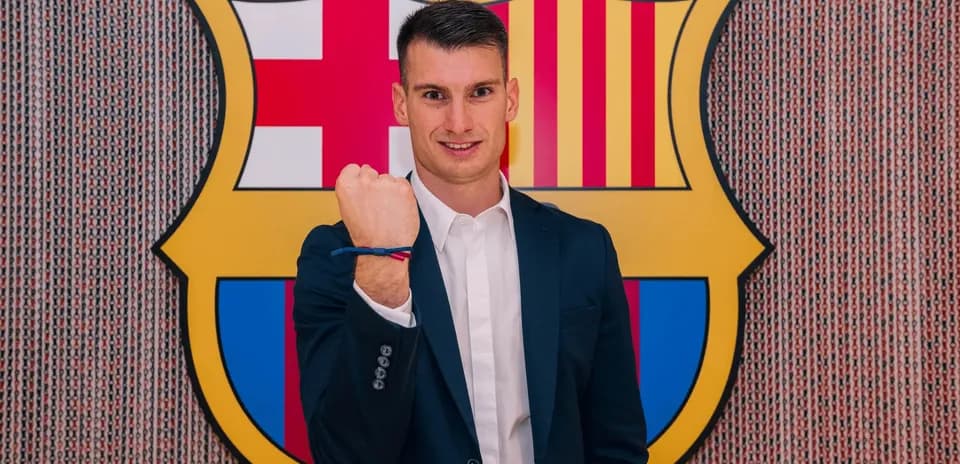 Player posing with clenched fist by Barcelona logo