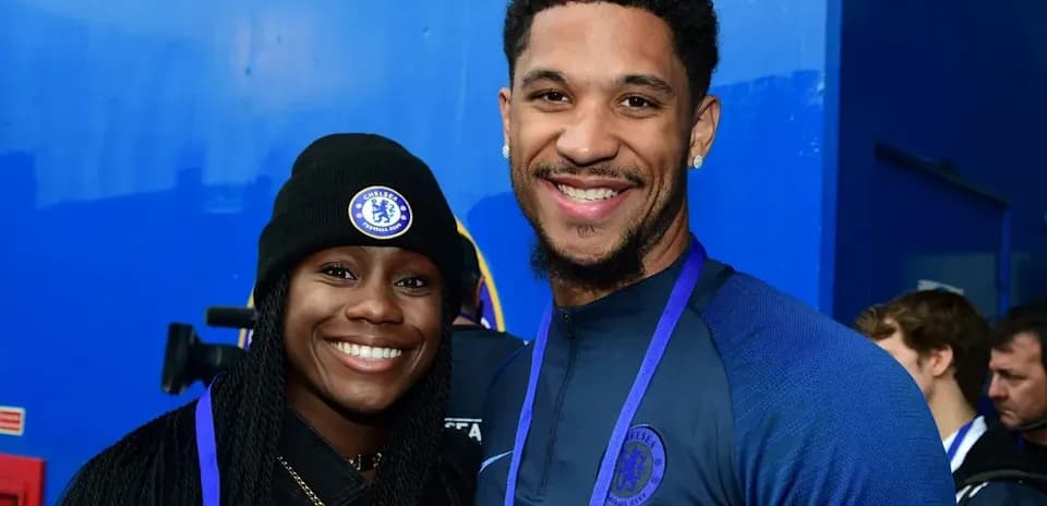 Two individuals smiling in Chelsea FC apparel