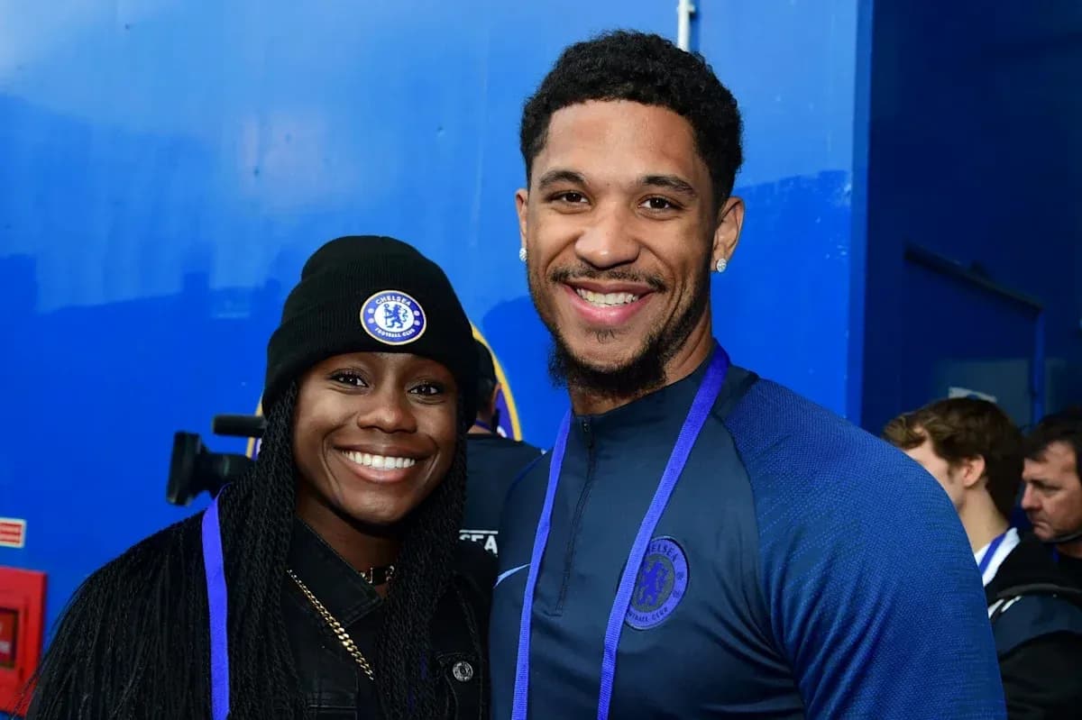 Two individuals smiling in Chelsea FC apparel