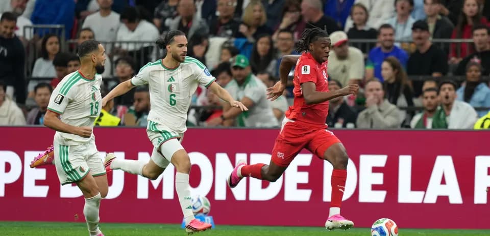 Switzerland player running past Algeria defenders