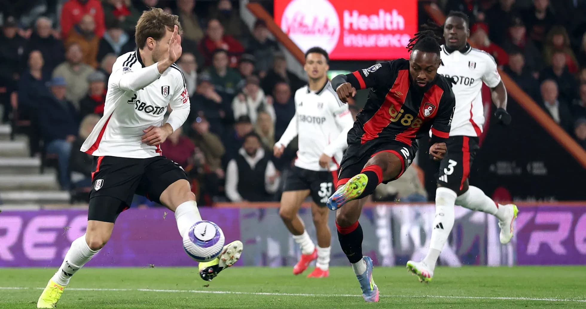 Fulham player tackling Bournemouth player during match