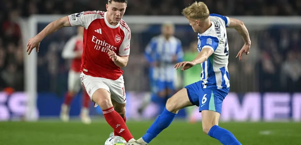 Brighton player challenges Arsenal player for the ball