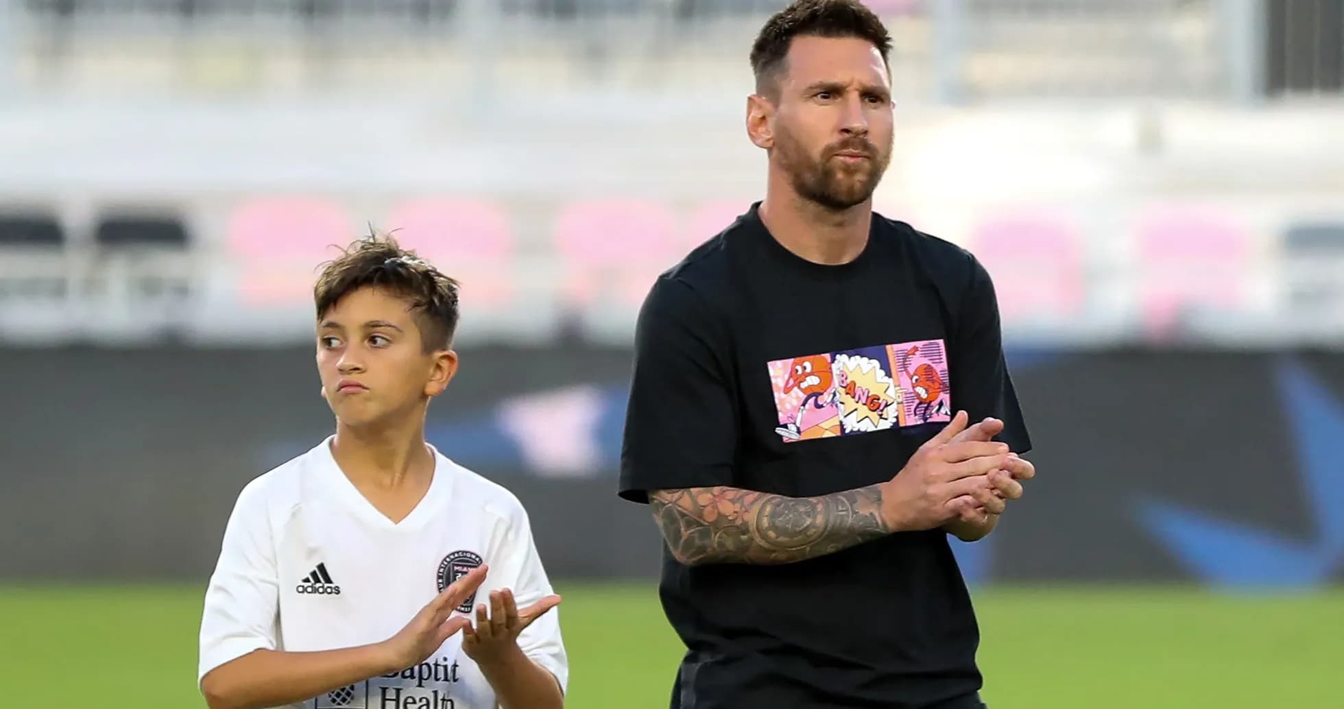 Lionel Messi and a child clapping on field