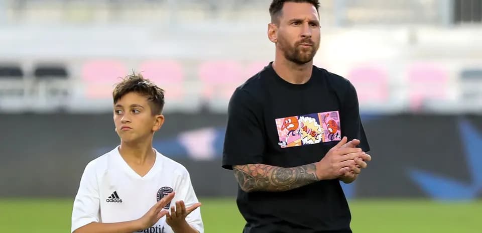Lionel Messi and a child clapping on field