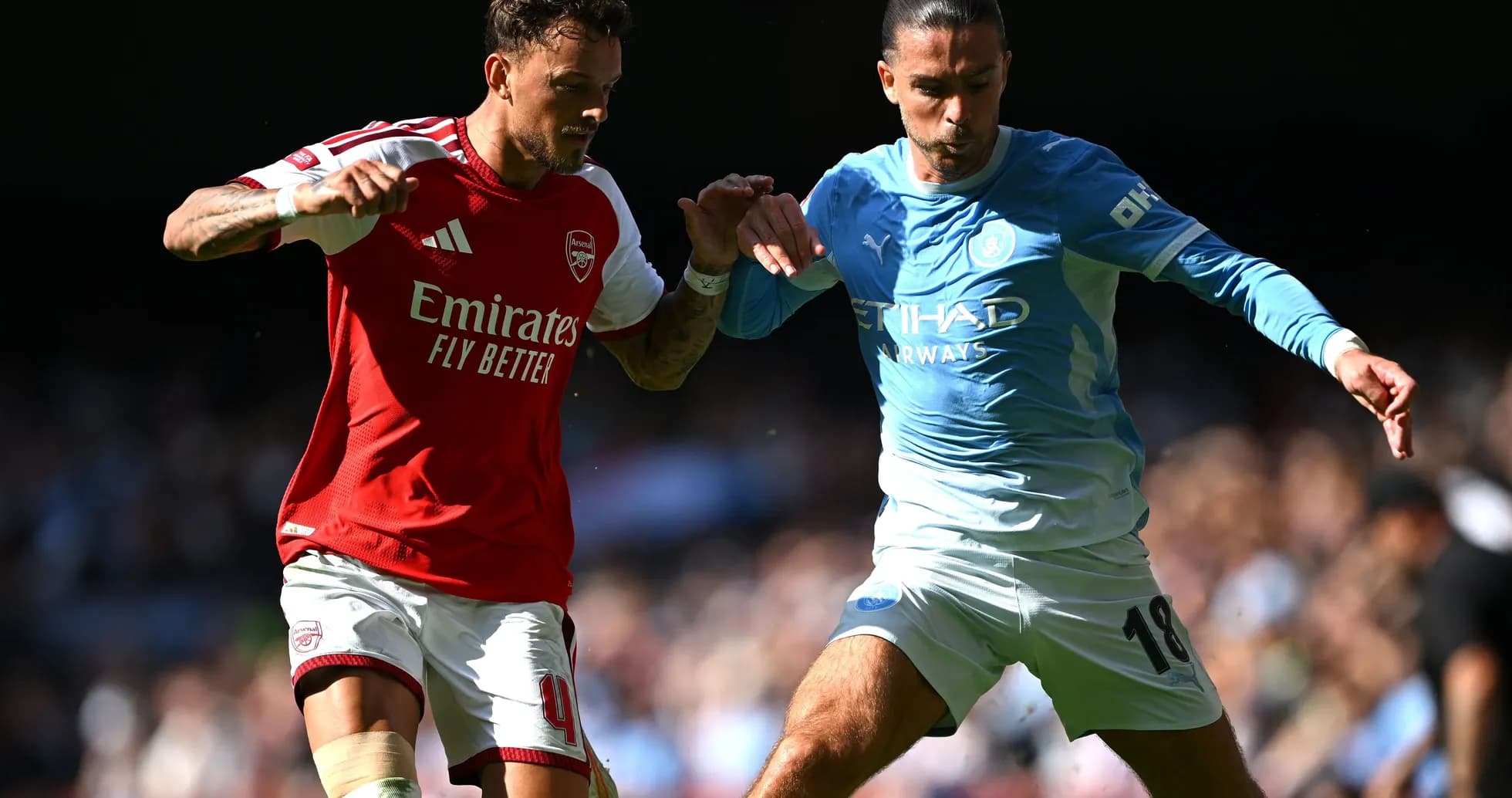Players from Arsenal and Manchester City contesting for the ball