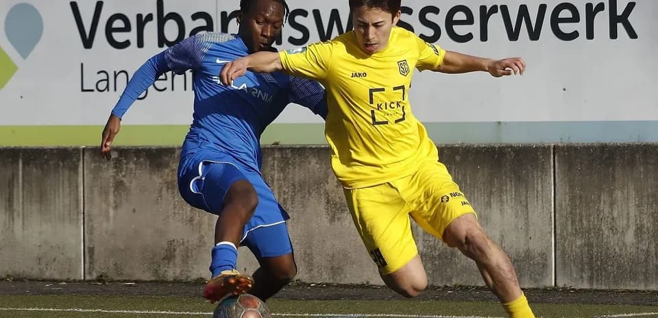 Two players competing for the ball in football