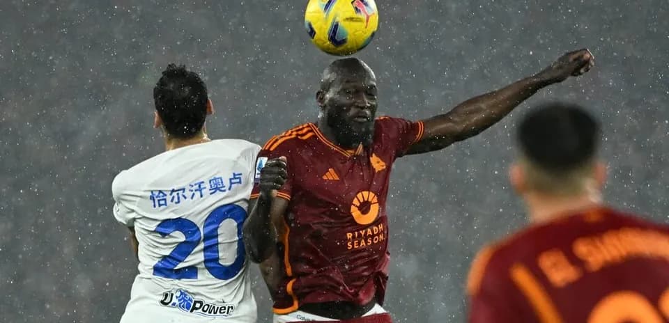 Players contesting a header in rainy match