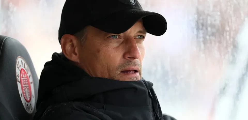 Coach observing from the bench during rainy match