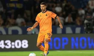 Player in orange kit dribbling ball during match