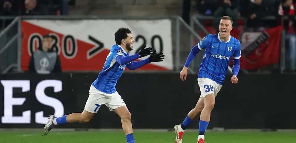 Two players celebrating a goal on the pitch