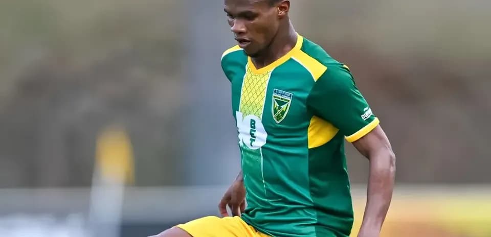 Player in green and yellow kit during match action
