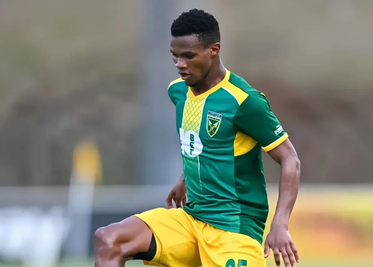 Player in green and yellow kit during match action