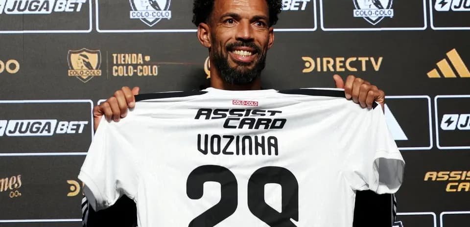 Player holding Colo-Colo jersey at presentation event