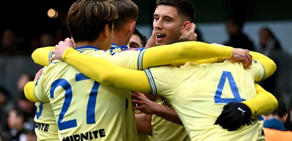 Players celebrating a goal in team jerseys