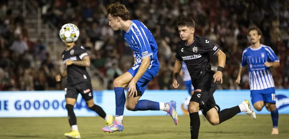 Player jumping to head the ball during match