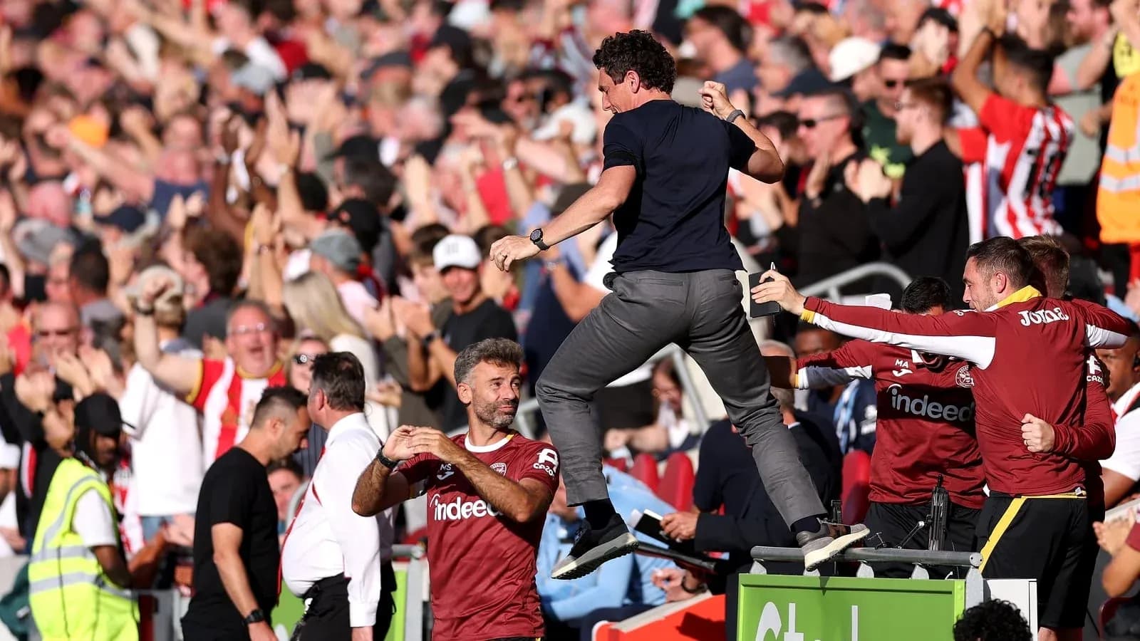 Celebration at stadium with fans and coaching staff