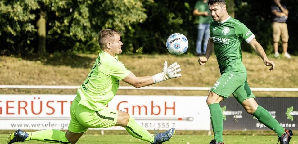 Goalkeeper attempts to catch the ball during match