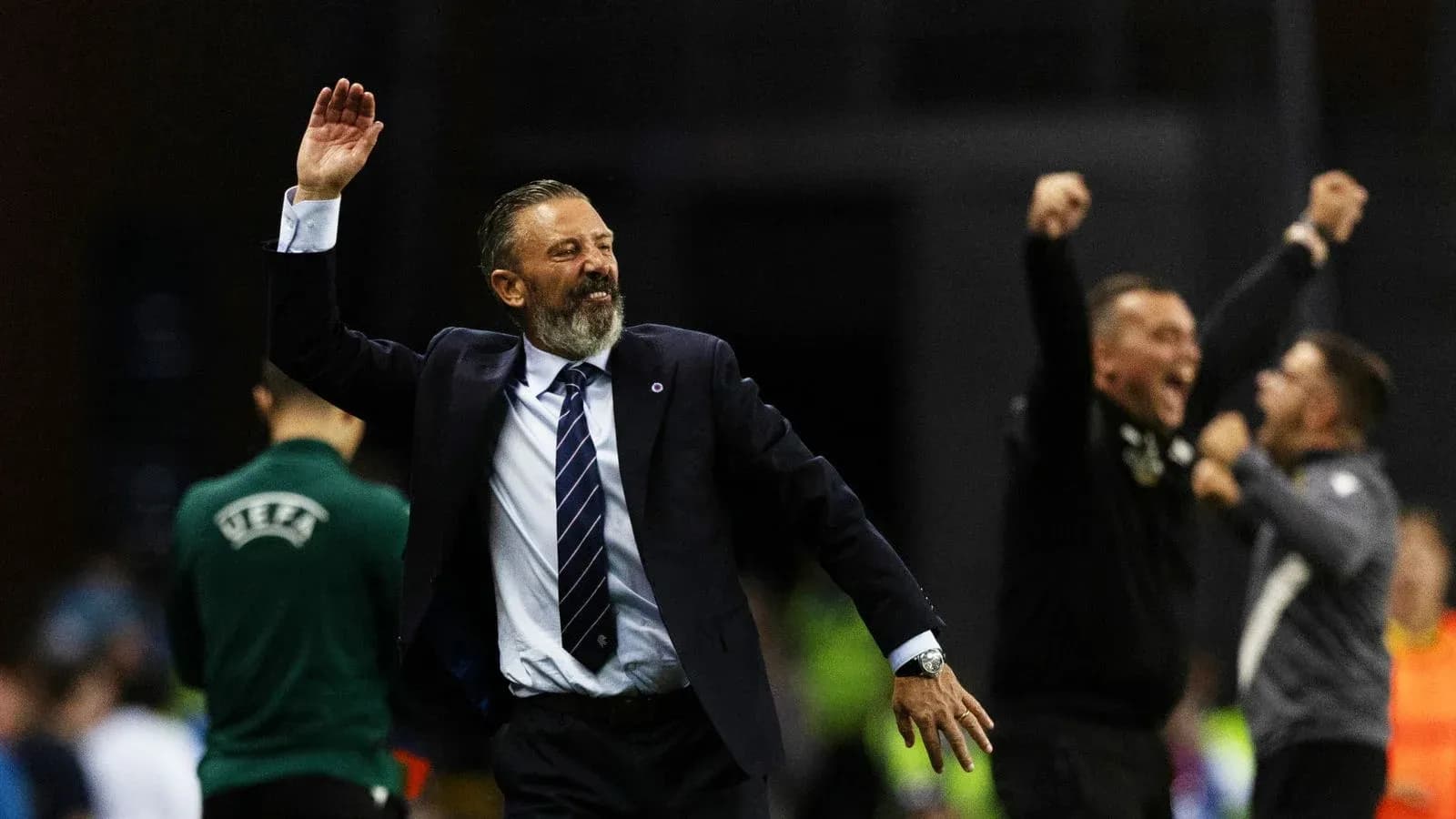 Coach celebrating victory with raised hand and smile
