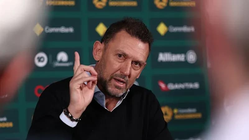 Coach speaking during press conference with gesturing hand