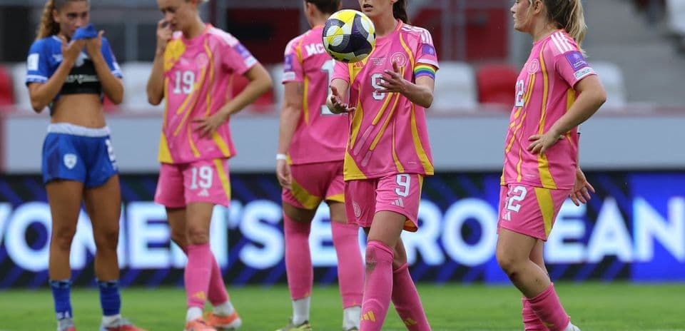 Players in pink uniforms on the field during match