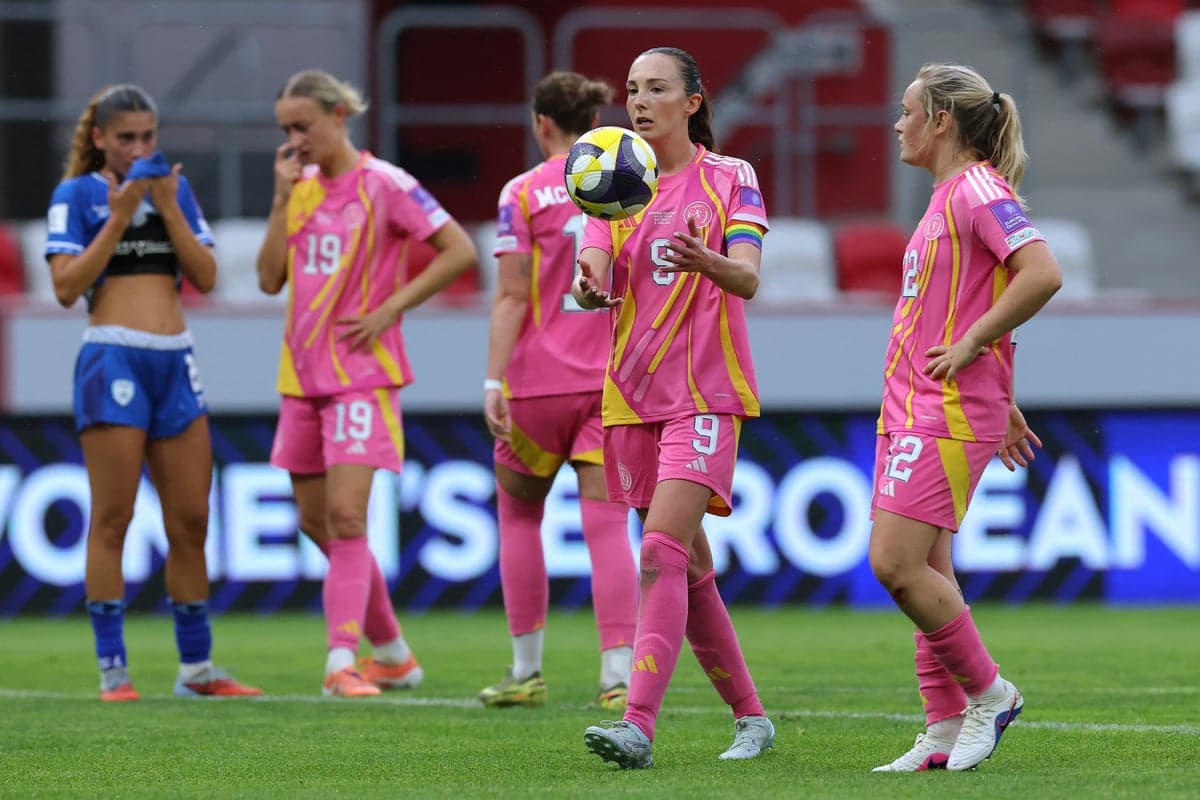 Players in pink uniforms on the field during match