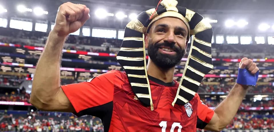 Player celebrating in red jersey with pharaoh headdress