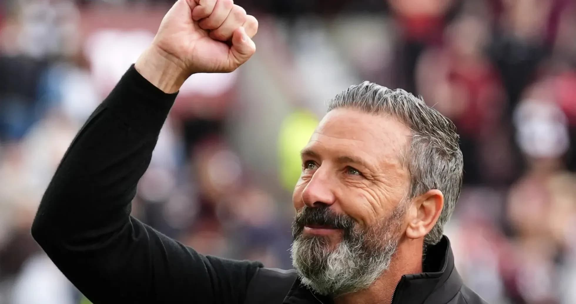 Coach celebrating with raised fist at stadium