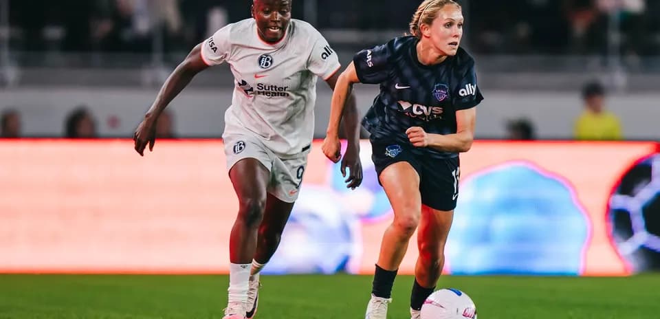 Two players competing for the ball in NWSL match
