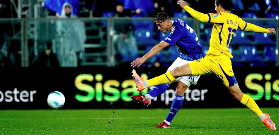 Hellas Verona player striking the ball against Como