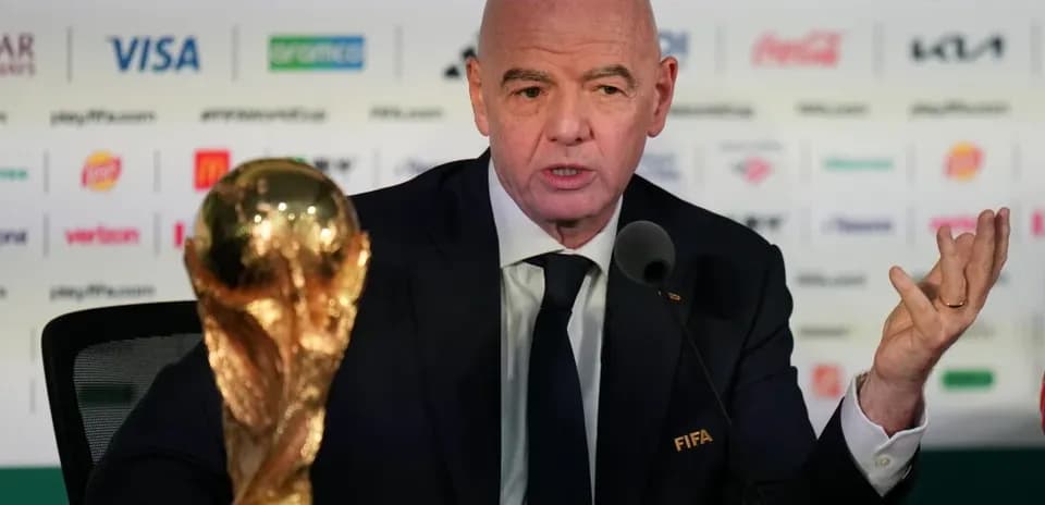 FIFA president speaking at press conference with trophy
