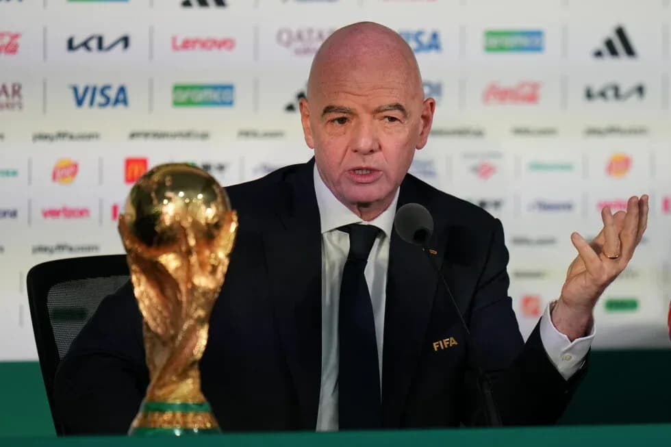 FIFA president speaking at press conference with trophy