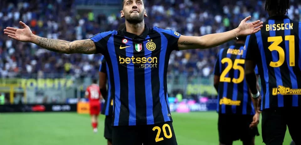 Player celebrating a goal with teammates in stadium