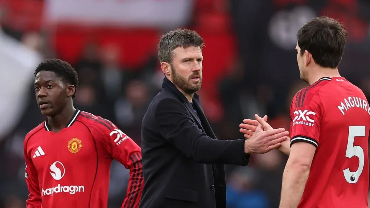 Manchester United players and coach interacting on pitch