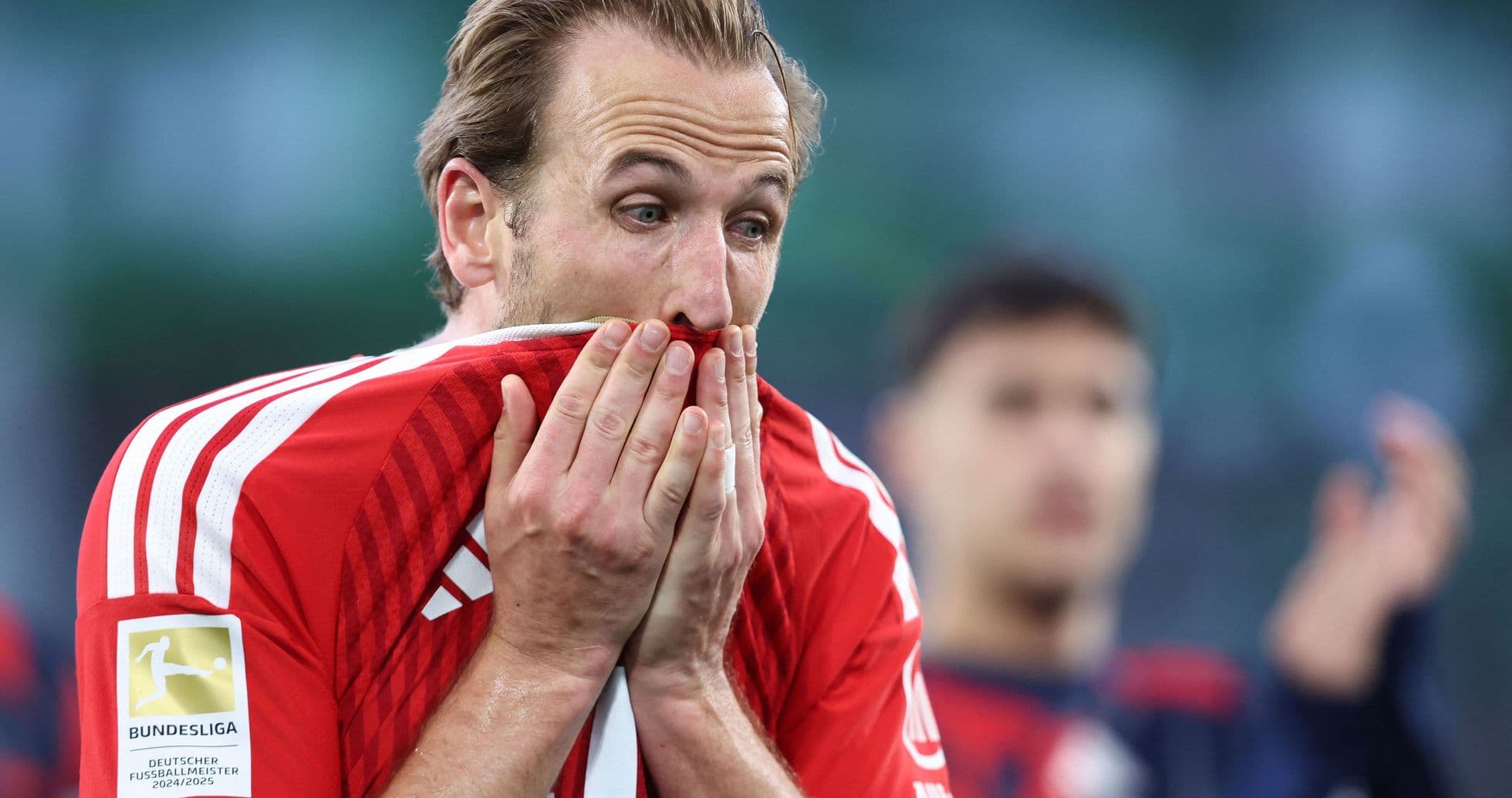 Player holding shirt to face after match