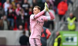 Goalkeeper applauding fans in pink kit