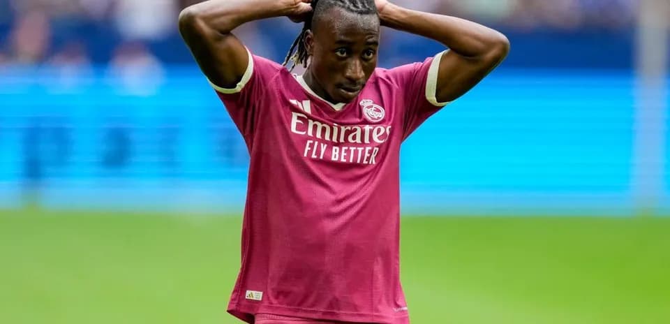 Player in pink kit with hands on head during match