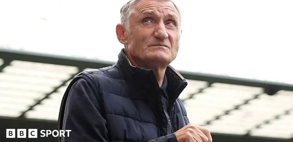 Person standing at stadium holding a bottle