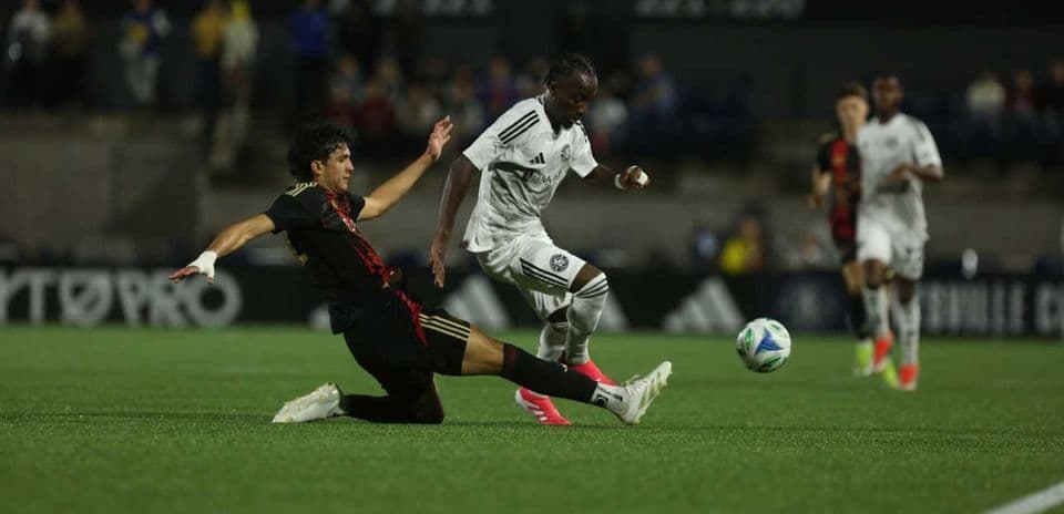 Player tackling opponent during Huntsville City match