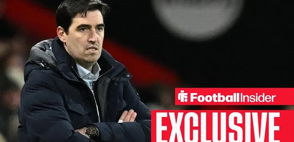 Coach observing match with arms crossed on sidelines