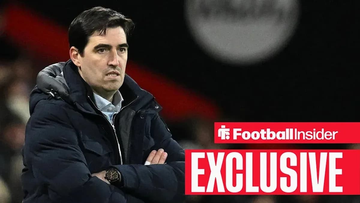 Coach observing match with arms crossed on sidelines