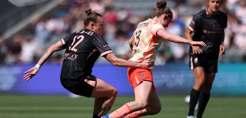 Player tackling opponent during NWSL match