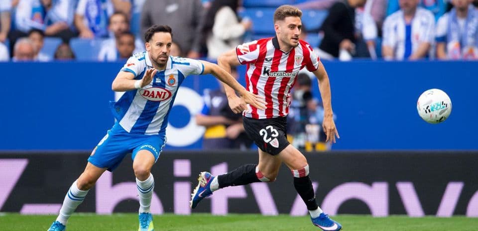 Espanyol player chasing Athletic Club opponent