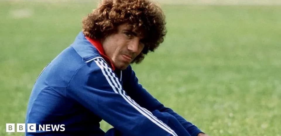 Player sitting on grass field in training outfit