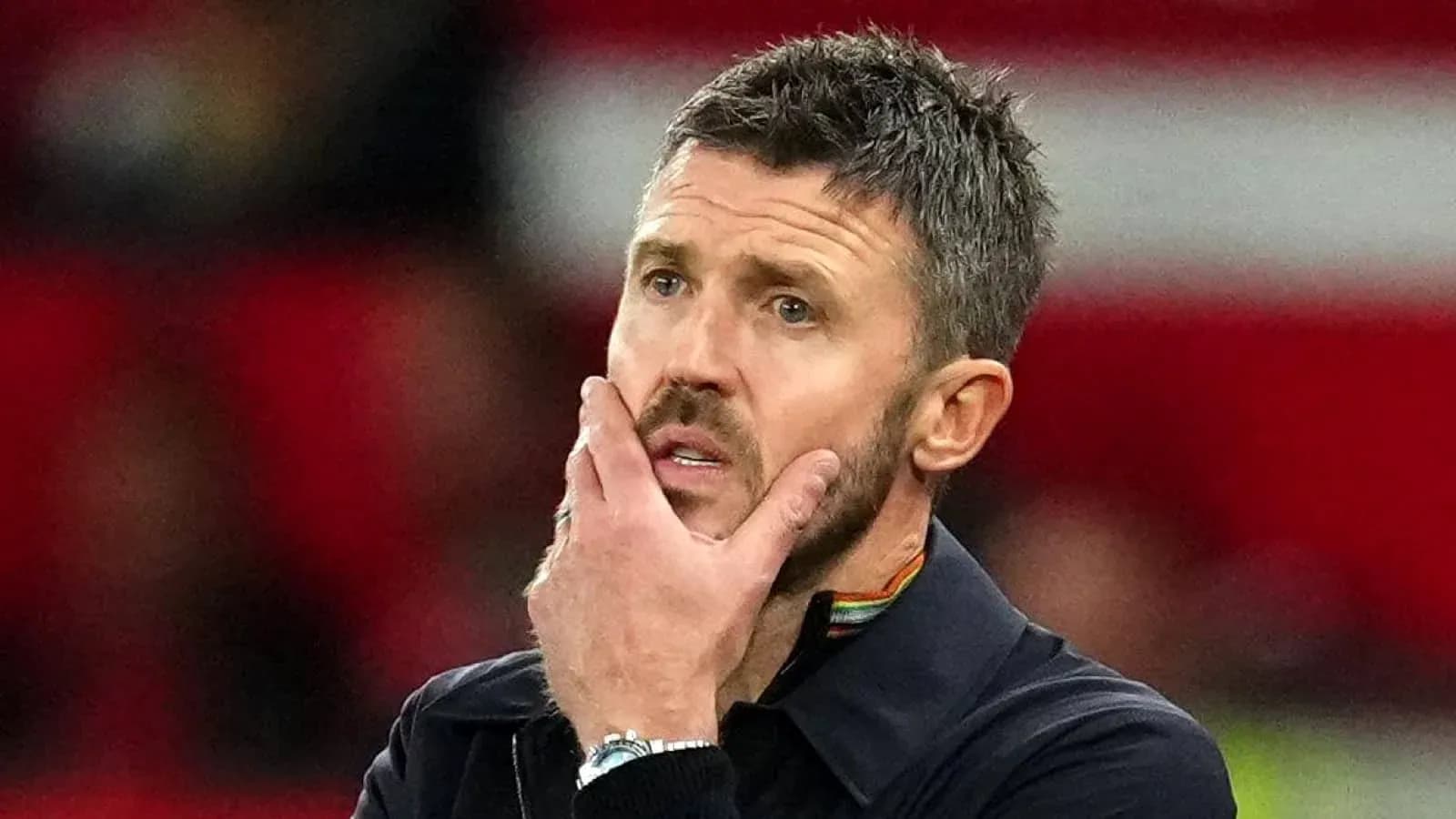 Coach with hand on face during match