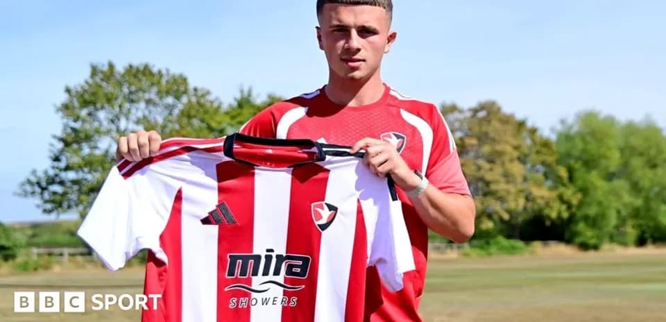 Player holding Cheltenham Town jersey at training ground