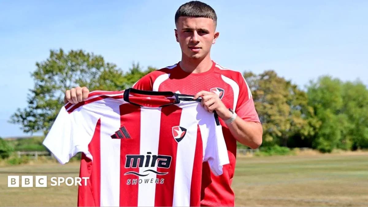 Player holding Cheltenham Town jersey at training ground