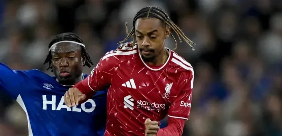 Liverpool player dribbling past opponent during match