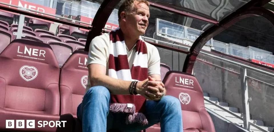 Manager seated on bench at football stadium