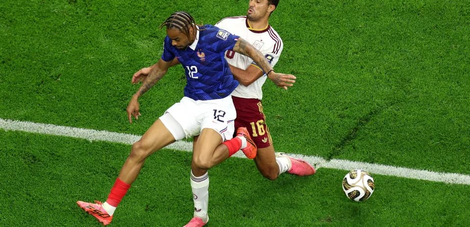 Two players competing for the ball on the field