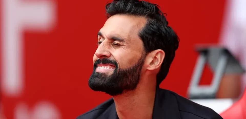 Man smiling while sitting on bench at stadium